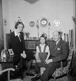 Rumsinteriör, familjegrupp tre personer.
Olle Eriksson