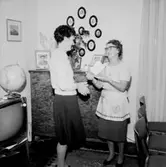 Rumsinteriör, två kvinnor. Personalklubben uppvaktar Dagmar Larsson på 60-årsdagen.
Örebro Kexfabrik.