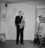 Holmströms orkester, en man med musikinstrument (saxofon).
Karlsson