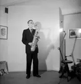 Holmströms orkester, en man med musikinstrument (saxofon).
Karlsson