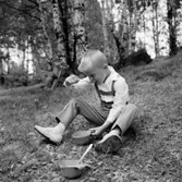 En pojke som äter, en man vid ett träd.