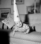 Rumsinteriör, en liten pojke i soffan, stjärngosse.
Beijer