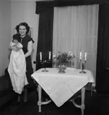 Rumsinteriör, en kvinna och ett litet barn. Barndop.
Eklund