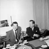 Interiör, två män, uppvaktning.
Wigrell & Co.