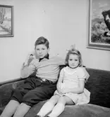 Rumsinteriör, en pojke och en flicka.
Hallberg