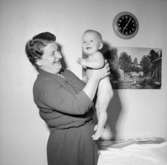 Rumsinteriör, en kvinna och en baby.Rudolf Rittbergs dotter, 4 månader gammal.