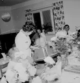 Rumsinteriör, grupp vid bordet, Kexens pensionärer. Personalklubben uppvaktar.
Örebro Kexfabrik.