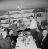 Rumsinteriör, grupp vid bordet, Kexens pensionärer. Personalklubben uppvaktar.
Sven-Olle avtackas.
Örebro Kexfabrik.