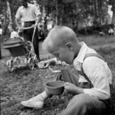 En man med ett barn i barnvagnen, en pojke som äter.