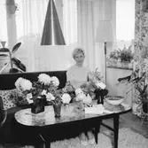 Rumsinteriör, en kvinna.
Fru Eva Nilsson på 40-årsdagen.