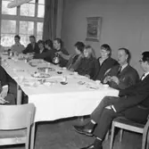 Rumsinteriör, grupp vid bordet, högtid.
Oscaria Skofabrik.