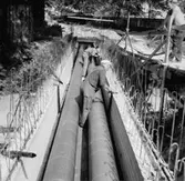 Byggnadsarbete, en man.
Fjärrvärmekulvert med fasta lock. Löst innerlock läggs på, armering viks ner och betong gjuts över det lösa locket.