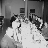 Rumsinteriör, grupp vid bordet. Personalklubben uppvaktar, Majgren avtackas.
Örebro Kexfabrik.