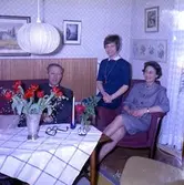 Rumsinteriör, familjegrupp tre personer, födelsedag.
Löfqvist