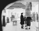 Klädutställning i Wadköping, interiör av utställningssalen, tre kvinnor.