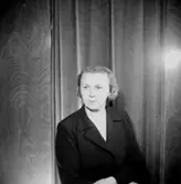 En kvinna.
Kläder från Jörnstedts damekipering.