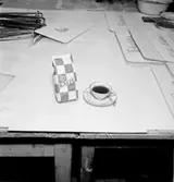 Konsum, interiör, kaffekopp och kaffepåse på bordet.