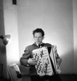 En man med musikinstrument (dragspel).
Holger Lindell