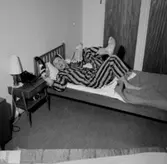 Sovrumsinteriör, en man i pyjamas vid telefonen, 