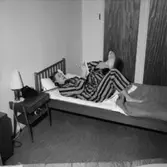 Sovrumsinteriör, en man i pyjamas vid telefonen, 