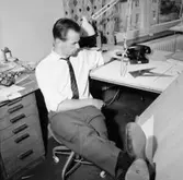 Kontorsinteriör, en man vid skrivbordet.
Sedell Reklam.