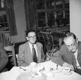 Rumsinteriör, grupp vid bordet, Oscarias pensionärer. Avtackning.