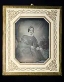 Daguerreotyp en kvinna.
Porträtt av Carin Carlsson, född Hansson, född i Grythyttehed, död den 2 april 1891.
Karin Janssons mormor.
Bilden tagen 1849 vid Loka.
Gåva från fru Hildur Jansson, Stockholm, genom Värmlands museum.