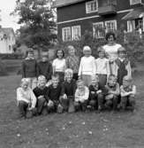 Ställdalens skola, skolbarn med lärarinna på skolgården, hösten 1962.
Skolbyggnad i bakgrunden.