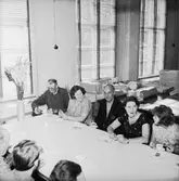 Verkstadsinteriör, grupp vid bordet, avskedsfest för Kalle Wärnberg.