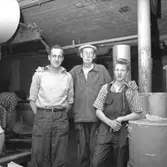 Verkstadsinteriör, grupp, tre män, avskedsfest för Kalle Wärnberg.