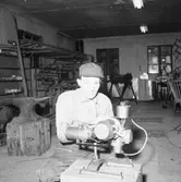 Verkstadsinteriör, en man.