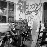 Verkstadsinteriör, en man.