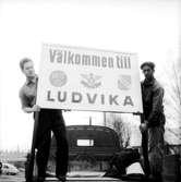 Två män med en skylt med texten: Välkommen till Ludvika.
Kjell Ramstedt
