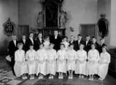 Konfirmander, elva flickor, nio pojkar och pastor Lövberg.
Interiör av Tysslinge kyrka.