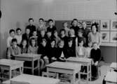 Olaus Petri nya skola, klassrumsinteriör, 26 skolbarn med lärarinna fru Karin Olsson.
Klass 6A, sal 6.