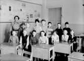 Engelbrektsskolan, klassrumsinteriör, 14 skolbarn med lärarinna fru Hildur Lien.
Klass 4Bd, sal 7.