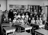 Klassrumsinteriör, 29 skolbarn med lärarinna.