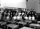 Klassrumsinteriör, 31 skolbarn med lärarinna.