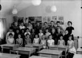 Klassrumsinteriör, 25 skolbarn med lärarinna.