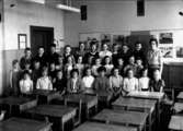 Klassrumsinteriör, 33 skolbarn med lärarinna.