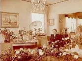 Byggmästare Arvid Erikssons fru på 50 årsdagen.
Rumsinteriör, en kvinna.