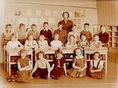 Vasaskolan, klassrumsinteriör, 20 skolbarn med lärarinna fru Britta Sandahl, klass 2s, sal 5 eller 16 (kortet togs i sal 16).