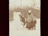 En kvinna och tre barn vid en snöhäst, framför fabriken Joh. Thermaenius & Son.
Sven, Carl-Edvard och Ulla Thermaenius