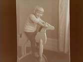 En liten pojke på leksakshäst.
Lennart Gustavsson (efter 1928 Gavenius)