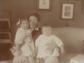 Rumsinteriör, familjegrupp tre personer.
Gerda Thermaenius med barnen Maj och Sven.