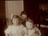 Rumsinteriör, familjegrupp tre personer.Gerda Thermaenius med barnen Maj och Sven.