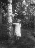 En flicka vid ett träd.