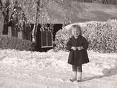 Flickporträtt. Barnporträtt. Snöbild. Liten flicka, Valborg, stående ute på snöig väg. Fastarpsvägen, Tvååker. Foto från omkring 1919.