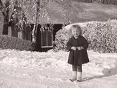 Flickporträtt. Barnporträtt. Snöbild. Liten flicka, Valborg, stående ute på snöig väg. Fastarpsvägen, Tvååker. Foto från omkring 1919.
