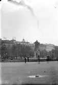 Kungsträdgården i Stockholm, en man och en pojke. Statyn föreställer Karl XIII.